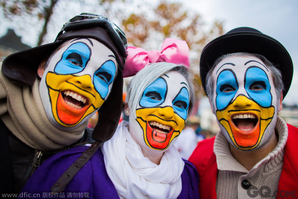 当地时间2014年11月11日，在德国杜塞尔多夫，狂欢者身着五彩斑斓的服饰，浓妆艳抹，将自己装扮成小丑庆祝狂欢节。