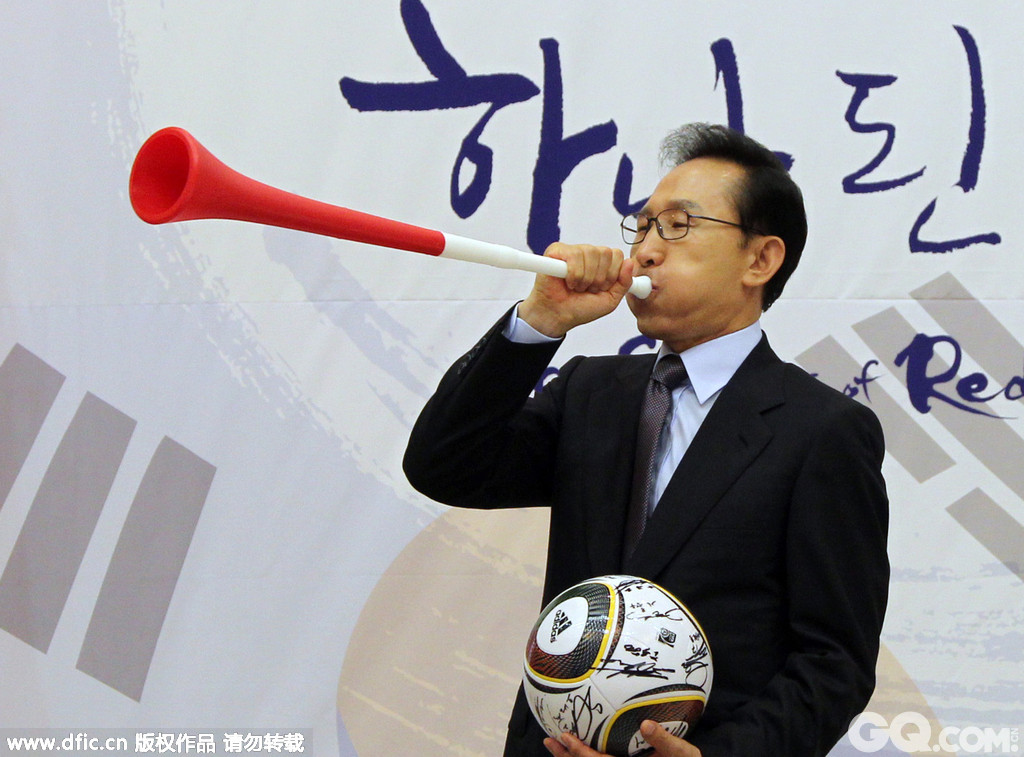 2010年7月6日，韩国首尔，总统李明博设宴款待回国的韩国队球员，宴会上，李明博手拿守门员赠送的呜呜祖啦卖力吹起来。
