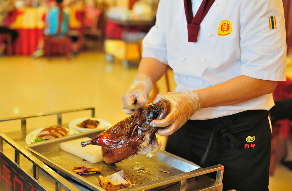 2012年8月24日，北京，全聚德和平门店的厨师正在分割烤鸭。可以说，作为北京美食“名片”的全聚德，凭借着老字号这个牌子，不仅赚到了足够的人气，更是赚得盆满钵满。