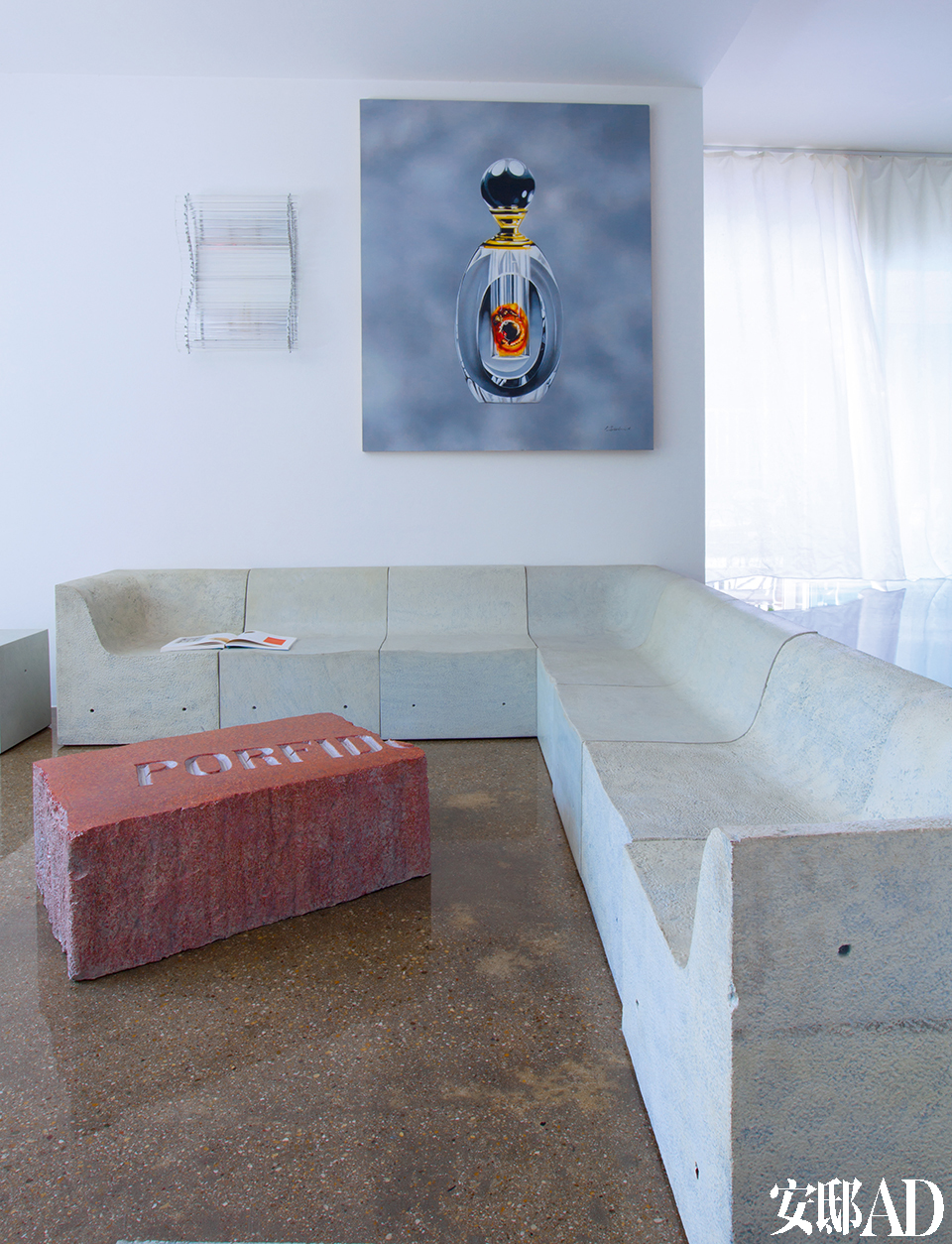 Gufram室内外兼用的沙发及咖啡桌，仿佛艺术装置，为客厅带来超凡气场。油画《六号香水》是Zhu Hai在2007年创作的。墙面上的玻璃壁灯名为“Nastri”，是意大利威尼斯Murano岛Venini在1999年出品的。名为“Softcrete”的组合沙发，是Ross Lovegrove于2007年设计的。客厅中央的茶几Massolo Piero Gilardi，是意大利品牌Gufram在1974年的作品。
