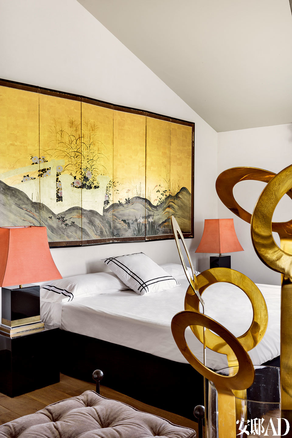 日本古董灯、 金色花瓶与床头画作相呼应，令满室璀璨金光得以提升。次卧的床头柜上，摆放着赛尔莲∙卡斯特拉挑选的1970年代的古董日本灯，而金色花瓶是在法国购买的，墙上的屏风壁画来自巴黎。