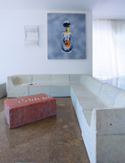 Gufram室内外兼用的沙发及咖啡桌，仿佛艺术装置，为客厅带来超凡气场。油画《六号香水》是Zhu Hai在2007年创作的。墙面上的玻璃壁灯名为“Nastri”，是意大利威尼斯Murano岛Venini在1999年出品的。名为“Softcrete”的组合沙发，是Ross Lovegrove于2007年设计的。客厅中央的茶几Massolo Piero Gilardi，是意大利品牌Gufram在1974年的作品。
