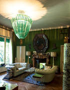 主人对古董家具的偏爱，淋漓尽致地体现在客厅的布置上。巨型绿色玻璃吊灯，把整个房间映照得朦胧梦幻。位于房子一层的绿色客厅。客厅里的长沙发来自20世纪60年代，Fornasetti家族的羊毛小地毯“Pavimento”由手工编织而成，Jacopo Foggini吊灯是由Metralicato生产的。