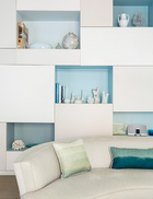 渐变的蓝色嵌入客厅的壁龛凹槽中，让色彩在墙面上活泼跳动。客厅中的特色定制壁橱，每一处凹陷的方格中都应用了深浅不同的蓝，富于变化。