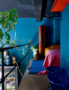 挑高空间搭出小夹层作为卧室，色彩鲜艳的床品别有洞天，淘气的绿植探头过来闯进梦乡。卧室里颜色鲜亮的床品来自Missoni，深色的复古屏风来自20世纪50年代。
