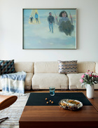 正是根据这张油画全家福，设计师为新家定下了整体色调。沙发上的几何图案靠垫来自BoConcept北欧风情，毯子购自ZARA HOME，不锈钢托盘由Alessi出品。
