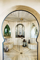 让人眼花缭乱的土耳其风格浴室中贴着脉纹的土耳其大理石，几个壁龛中铺设着镜面马赛克，花洒来自Waterworks。