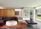 开放的起居空间是这个家的主体，沙发Exclusif来自Ligne Roset，沙发床来自Tonic Design。近处墙上的艺术品名为“The Battle Between Yes and No”，是南非艺术家William Kentridge创作的丝网版画。
