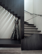 通往楼上的楼梯，黑钢打蜡，出自Elliott Barnes。楼梯下面，Suzy Gomez的金属作品《Obra》，呈现出裙子的形状。
