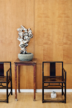 这是两把19世纪的中式玫瑰椅，中间是19世纪的中式马蹄腿方形花盆架，艺术家展望的不锈钢山石盆景，摆在花盆架上。中式家具营造的复古氛围里，当代艺术家展望的不锈钢雕塑成为神来之笔。
