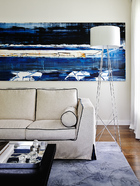 澳大利亚抽象表现派艺术家John Firth-Smith的作品《Storm Light》为客厅提供了蔚蓝的主色调，人造丝和亚麻布料的Lutetia Vestis沙发为Maxalto品牌，白色落地灯Ray来自Flos。Nexus Design设计事务所的创意总监SoniaSimpfendorfer女士和地毯艺术家Bibi Viro为该居室定制了竹纤维和羊毛混纺的地毯。