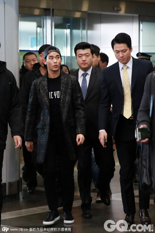 12月6日北京，金秀贤结束北京某商业见面会后，现身首都机场。我们看到了今年冬天风衣配球鞋的常见穿法，反戴球帽和标语黑T至少能让人年轻五岁吧。