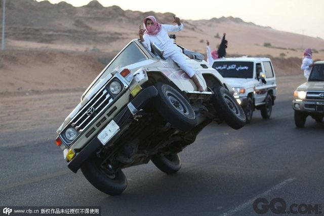 当地时间2014年12月3日，沙特阿拉伯塔布克，沙特青年马路表演两轮侧行特技。