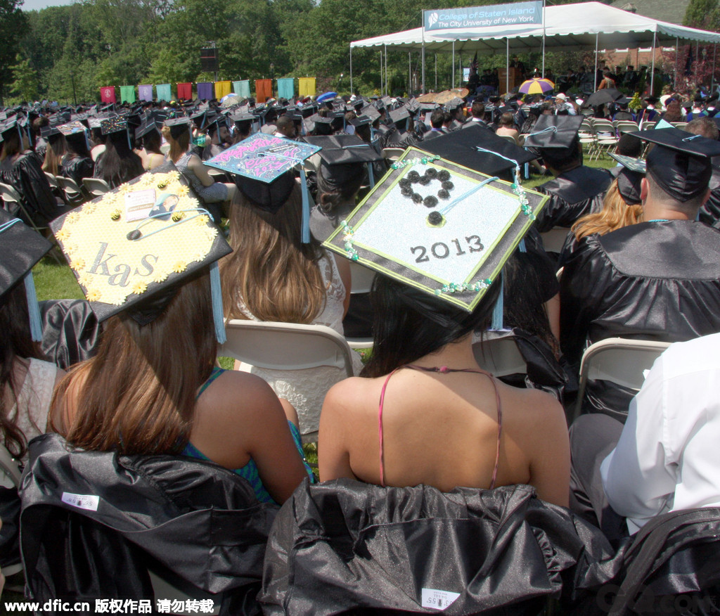 2013年5月30日，美国史坦顿岛，参加毕业典礼的女大学生嫌天气太热，脱掉学士袍大露香肩。  