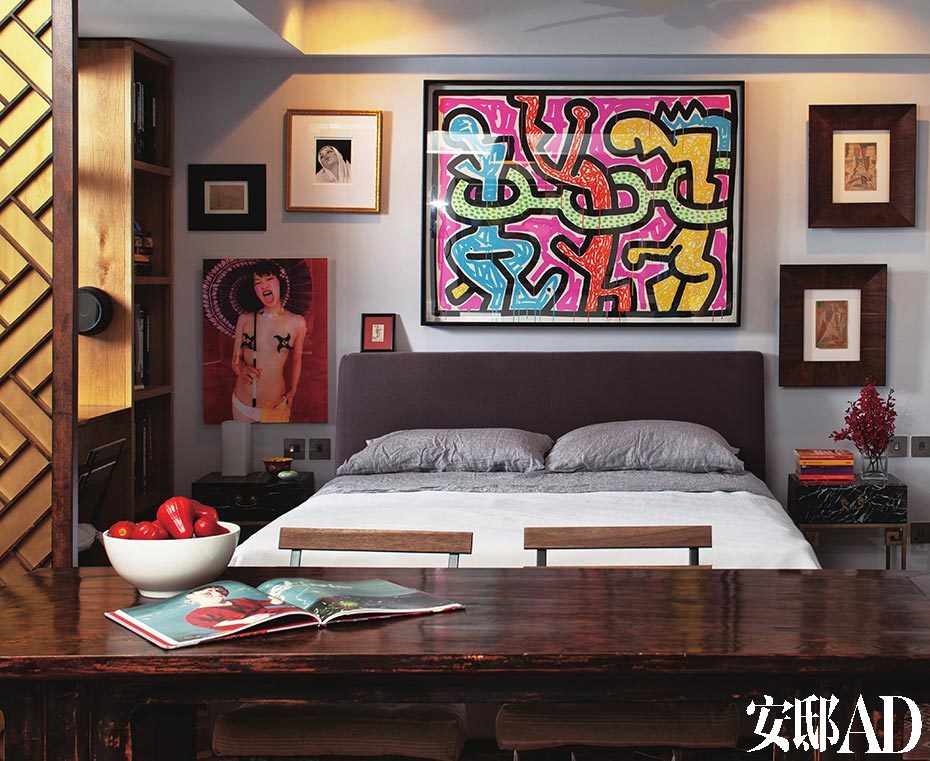 移开屏风，便是卧室空间，原来狭窄局促的卧室如今豁然开朗，颜色亮丽的Keith Haring绘画和蜷川实花的摄影作品更让这里气氛活泼，一对大理石床头桌也是主人Del Vecchio的设计。