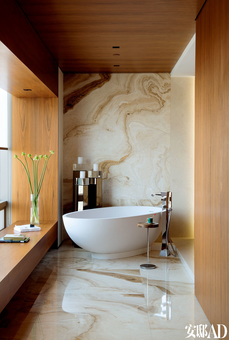 与主卧室相通的开放式浴室，Agape陶瓷浴缸由Fmarti Guixe设计，购自北京德丽堡建材商贸，金属小茶几来自Ligne Roset。宽敞的主卧室选择了中性色调，Society绿色床品来自Lane Crawford连卡佛。