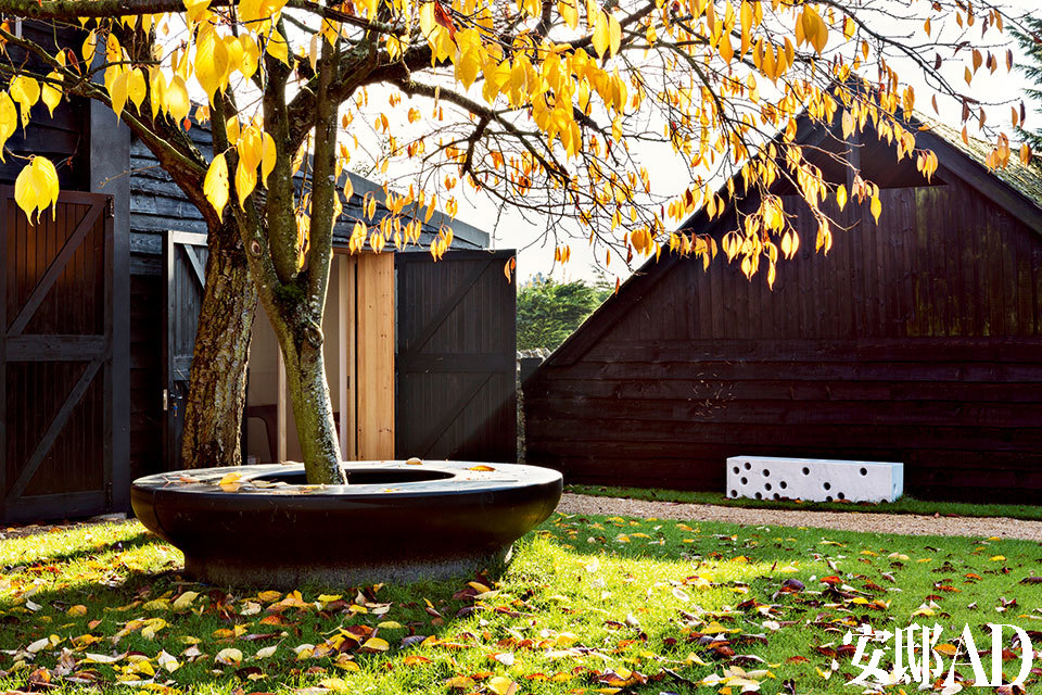 院落中围绕大树的一圈黑色花岗岩石凳由Edward Barber和Jay Osgerby特别设计，远处的白色卡拉拉大理石长凳也是他们的作品。