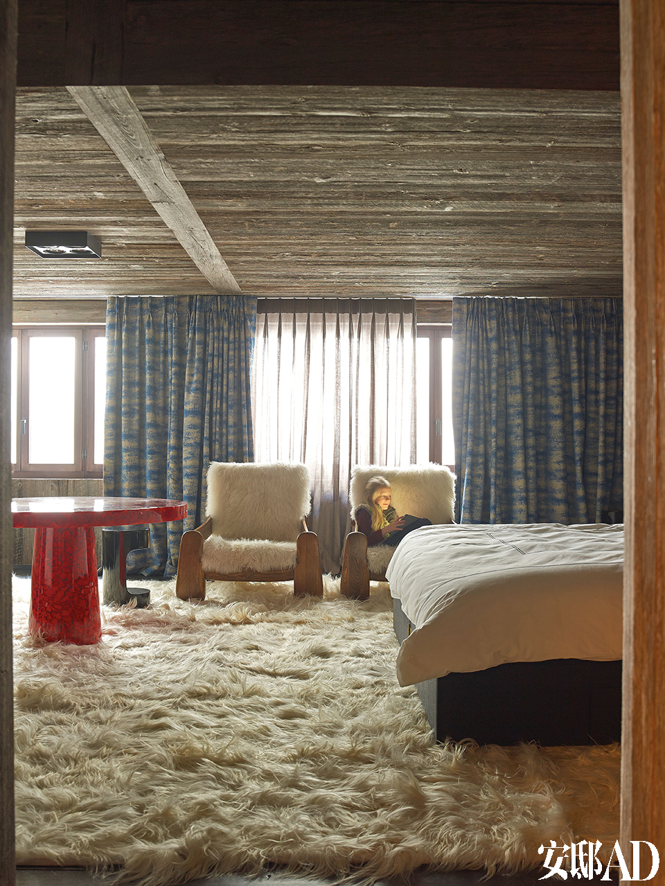 铺满地面和扶手椅的长山羊毛地毯显示出浓郁的北欧风情，窗帘和窗纱来自Jules et Jim Paris，红树脂片制成的桌子由Jean Brand设计，Atelier Janus出品。
