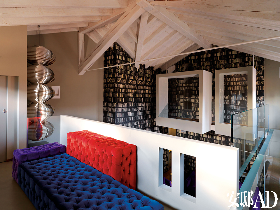 阁楼上可以清楚地看到坚持用纯手工打造的全新屋脊，彩色Michetta天鹅绒沙发组合是Gaetano Pesce为Meritalia品牌设计的。