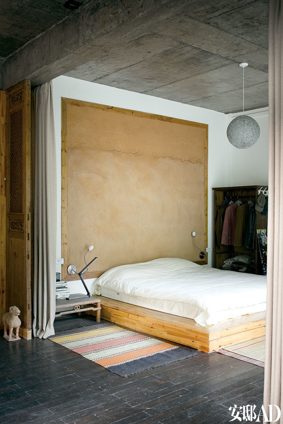 卧室中刻意用木框装饰出一面土墙，它由号称“三宝经典材料”的景德镇釉泥糊成。
