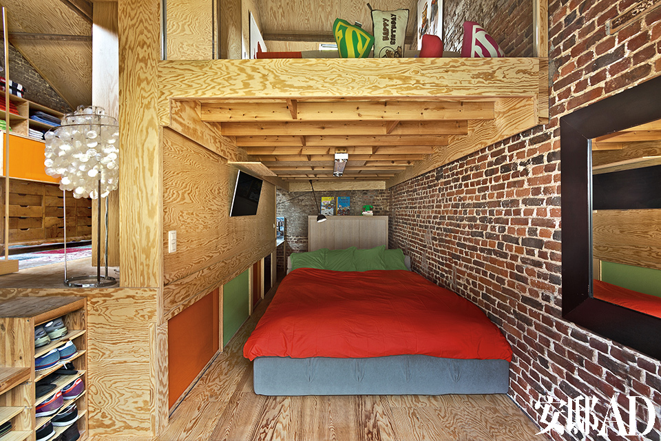 主人的卧室同样应用了木质嵌板以及带彩色推拉门的储物柜。