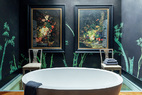 浴室位于二层，靠墙的一半地板大胆地采用了玻璃材质。淋浴的花洒在天花板上，水直接从上面洒下，让洗澡也变成审美享受。壁纸是de Gournay中式系列的Bamboo。