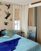 主人女儿的卧室中，连木格栅都调成了彩色，床头墙面挂的实际是一块地毯，地上的画作来自Huang Yi Shan。
