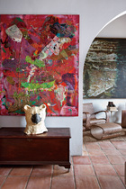 卧室内挂有Angel Otero的红色画作，熊头形状艺术品来自Anne Chu。右侧是Peter Doig的画作。
“因为这些作品的创造者彼此也是很好的朋友，我们收藏的作品之间存在着一种和谐共鸣，这正体现了一种友谊的精髓。”