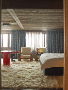铺满地面和扶手椅的长山羊毛地毯显示出浓郁的北欧风情，窗帘和窗纱来自Jules et Jim Paris，红树脂片制成的桌子由Jean Brand设计，Atelier Janus出品。