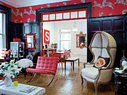 客厅以及主人的餐厅兼书房中，黑红主色调以及各种风格的混搭效果非常惊艳。天然白的经典连帽座椅购于纽约Restoration Hardware，一旁是红色的“巴塞罗那”椅，靠墙的金色巴洛克式镜子购自Horchow。